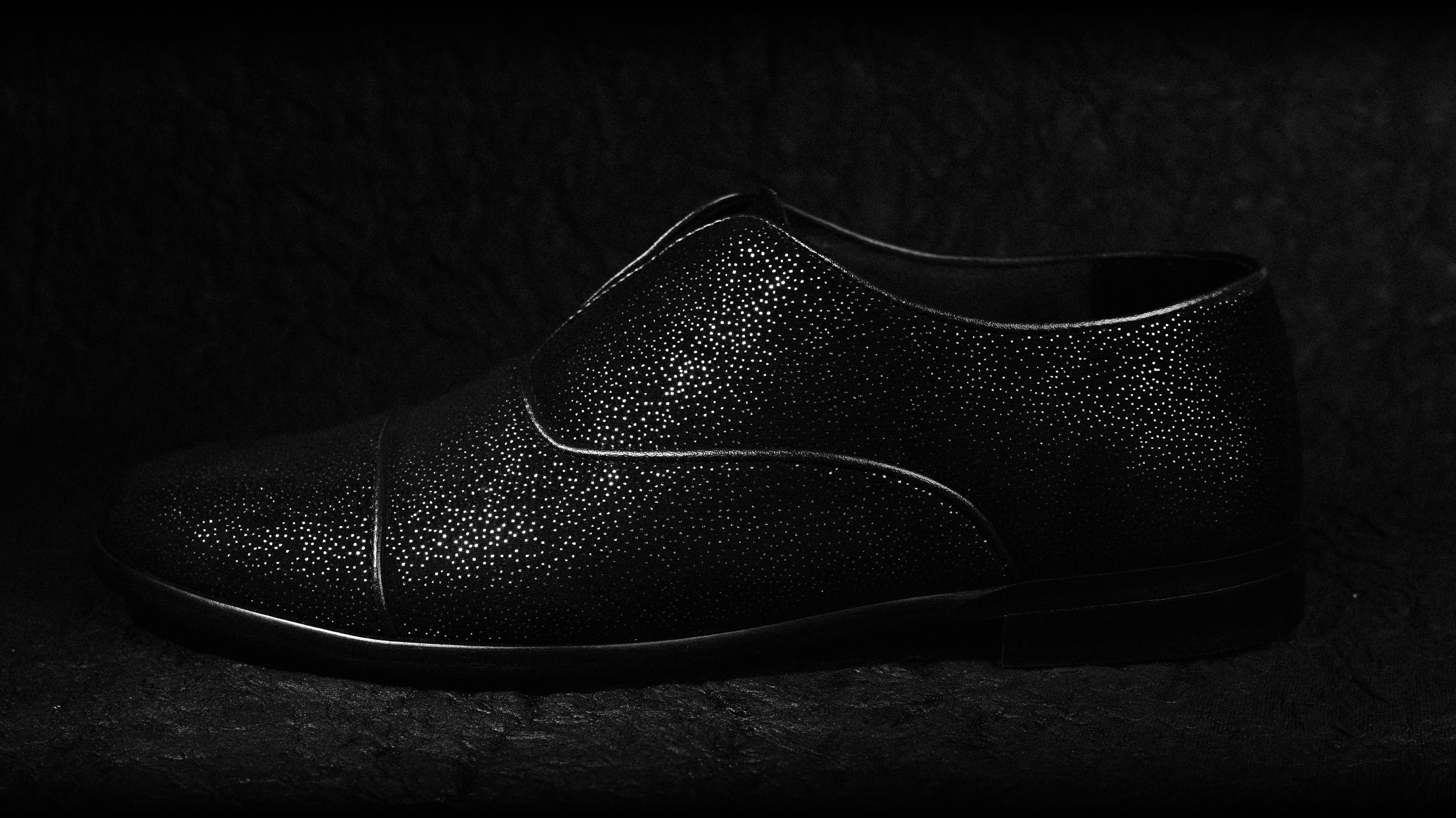 A black leather shoe on a black background.