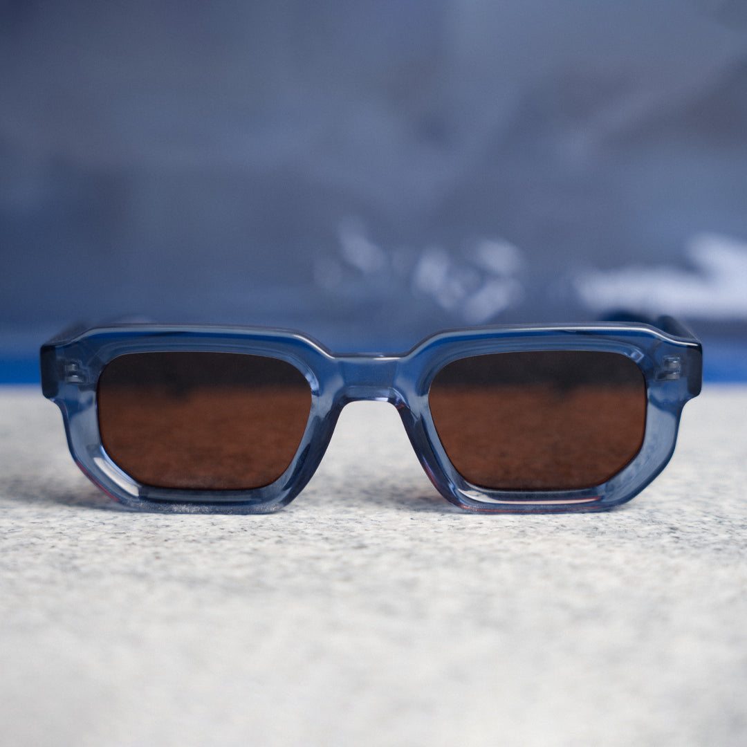 A pair of monkstory geometric acetate unisex sunglasses in transparent blue with brown lenses offering UV 400 protection.