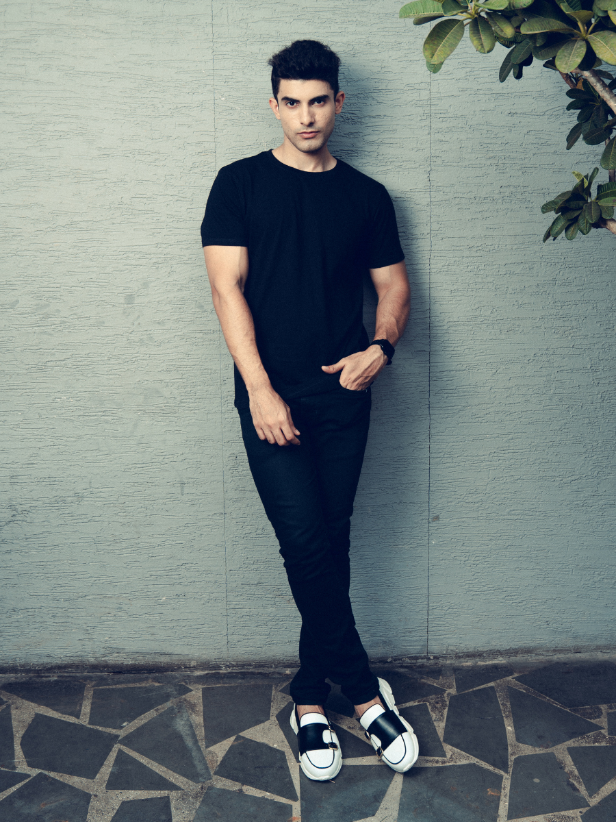 A man wearing a black t-shirt with a pocket, showcasing the Monkstory Bamboo Cotton Crew Tee - Classic Black for unmatched softness.