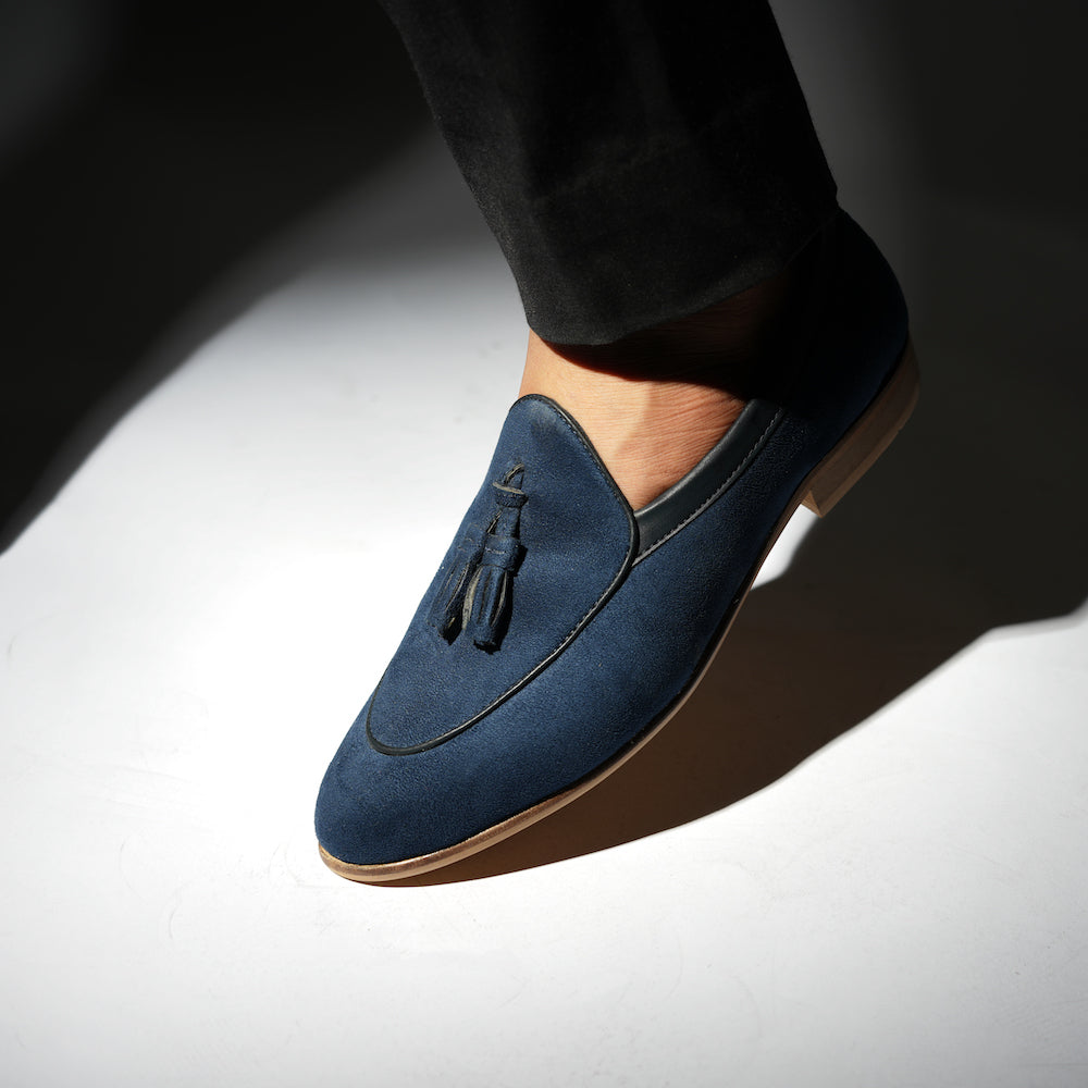 An eco-conscious blue suede Monkstory loafer with tassels, showcasing sustainability.