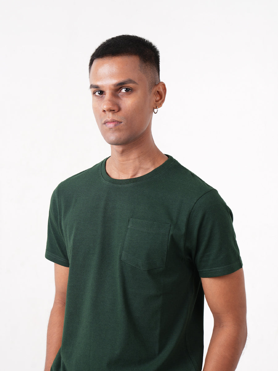 A man wearing a Monkstory Bamboo Cotton Crew Tee - Bottle Green with a pocket.