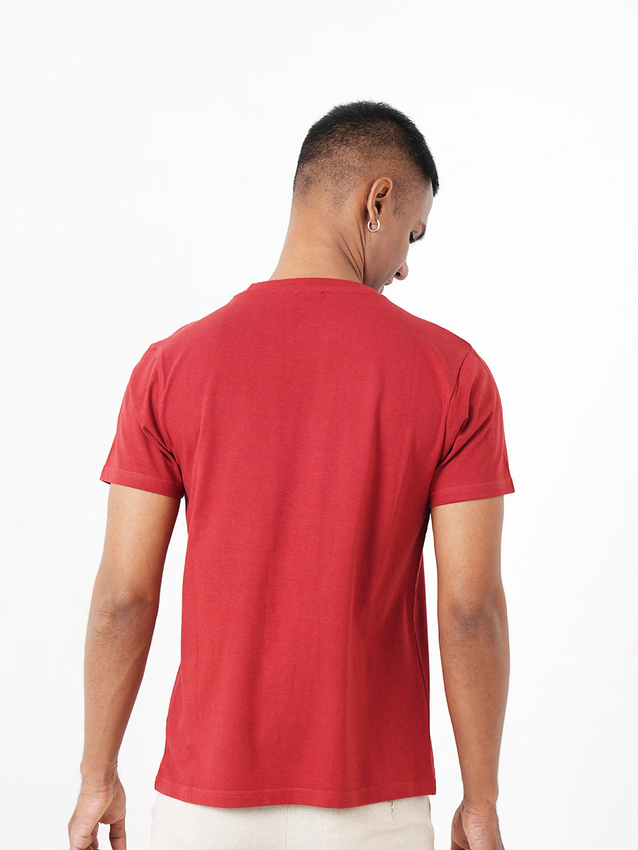 A young man in a Monkstory Bamboo Cotton Crew Tee - Terracotta Red is posing for a photo.