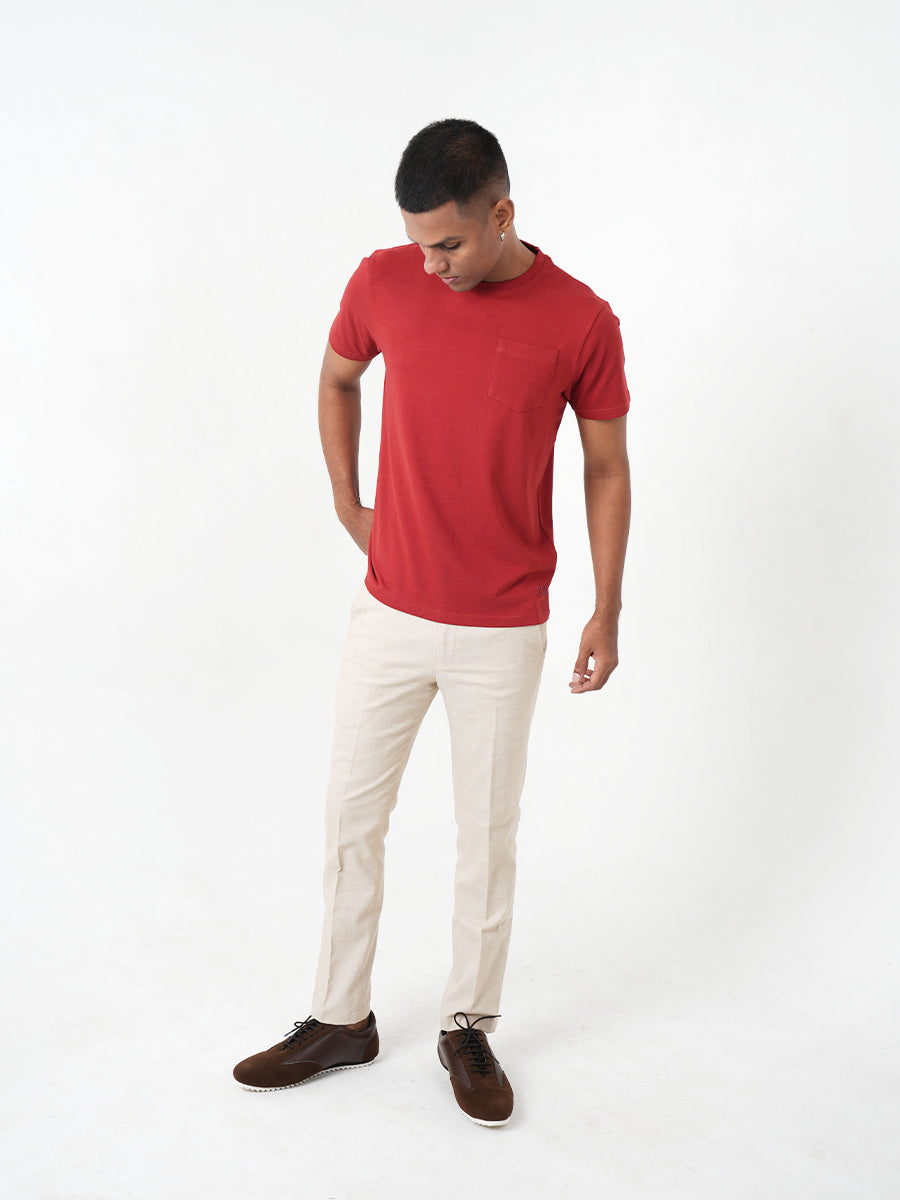 A young man in a Monkstory Bamboo Cotton Crew Tee - Terracotta Red is posing for a photo.