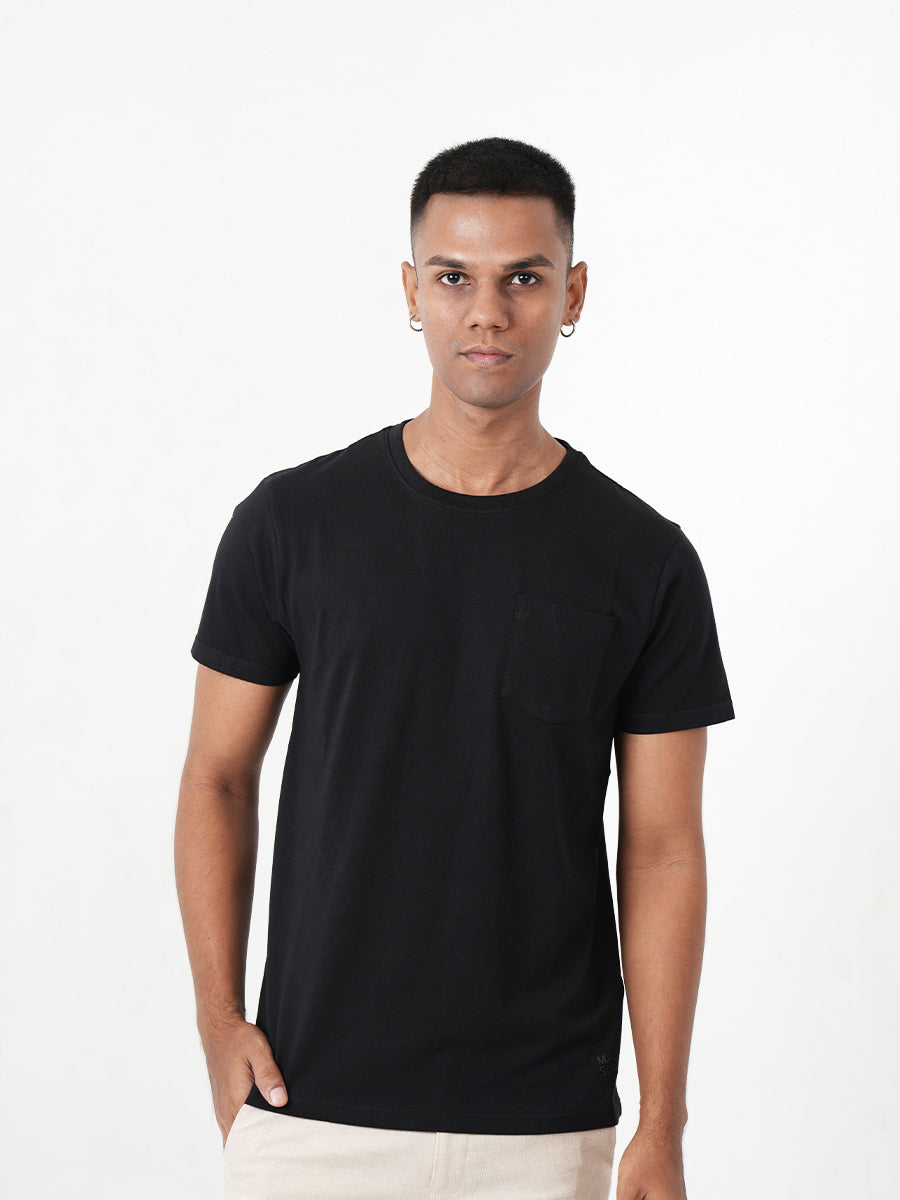 A man wearing a black t-shirt with a pocket, showcasing the Monkstory Bamboo Cotton Crew Tee - Classic Black for unmatched softness.