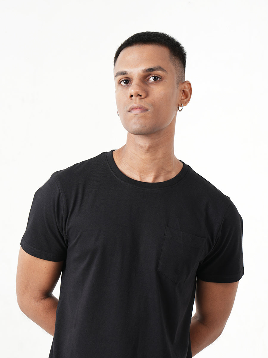 A man wearing a black t-shirt with a pocket, showcasing the Monkstory Bamboo Cotton Crew Tee - Classic Black for unmatched softness.