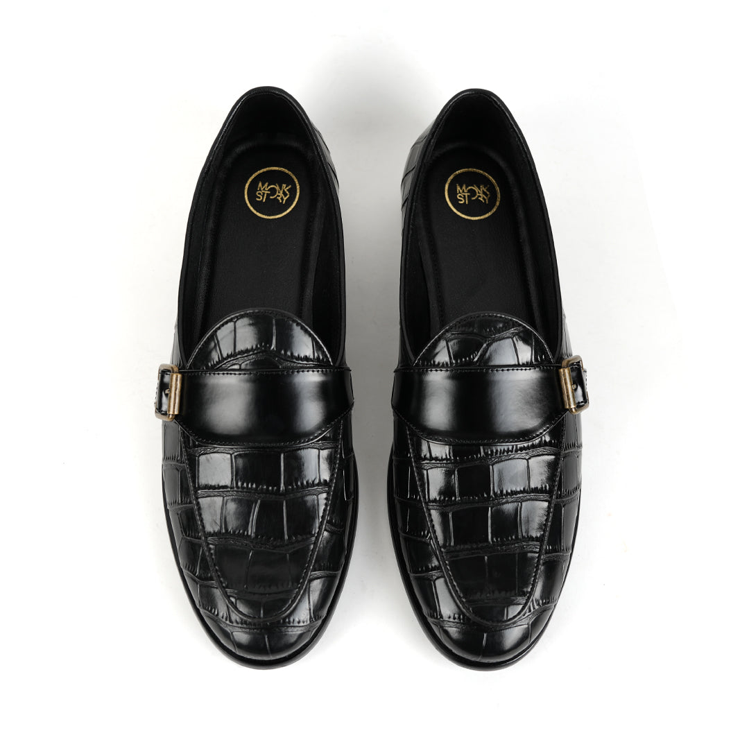A sleek black Monkstory Croco Print Formal Shoes with a gold buckle.