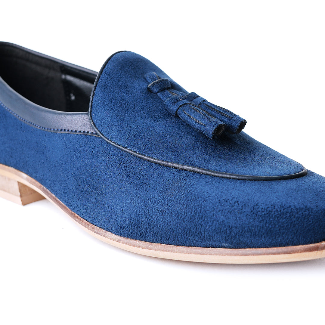 An eco-conscious blue suede Monkstory loafer with tassels, showcasing sustainability.