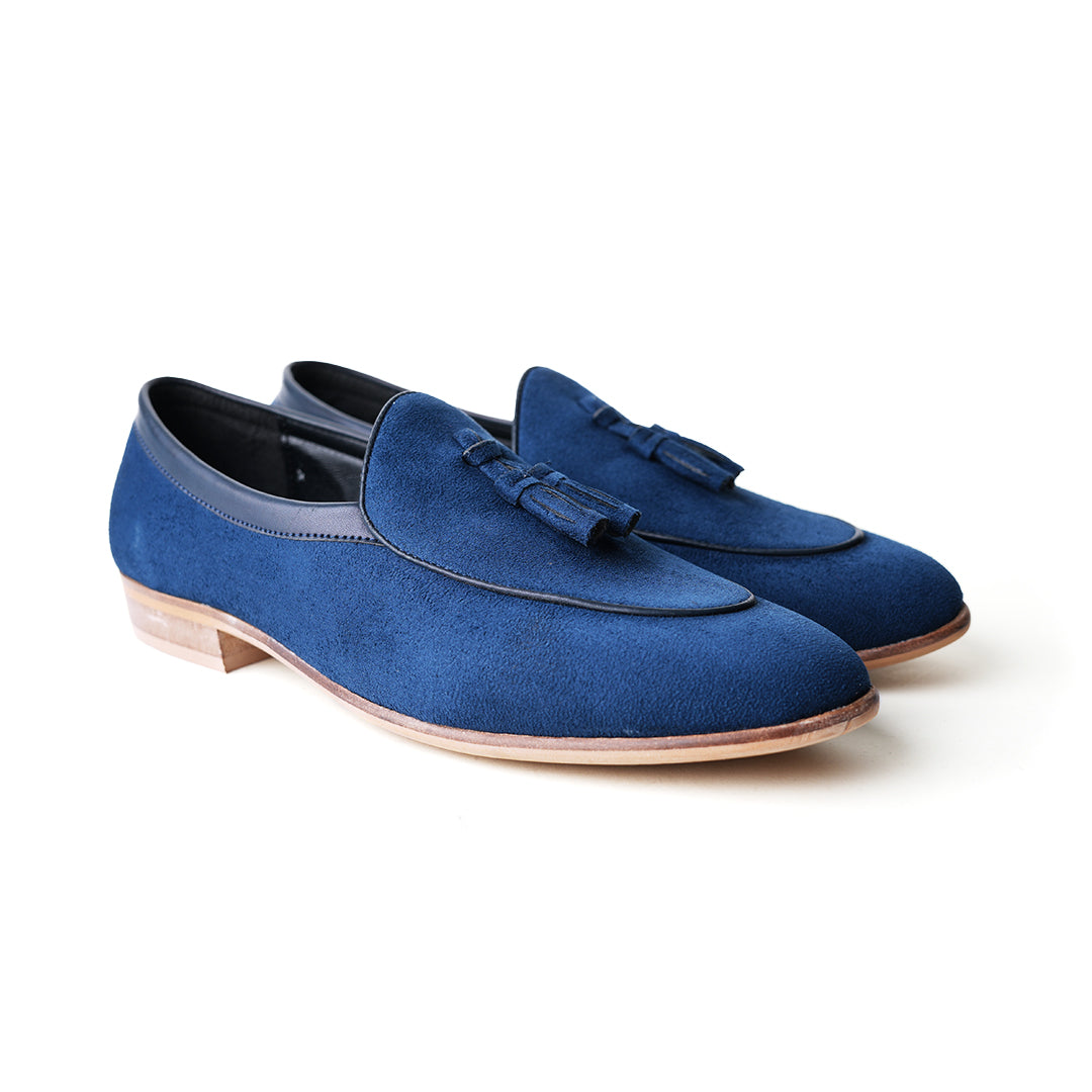 An eco-conscious blue suede Monkstory loafer with tassels, showcasing sustainability.