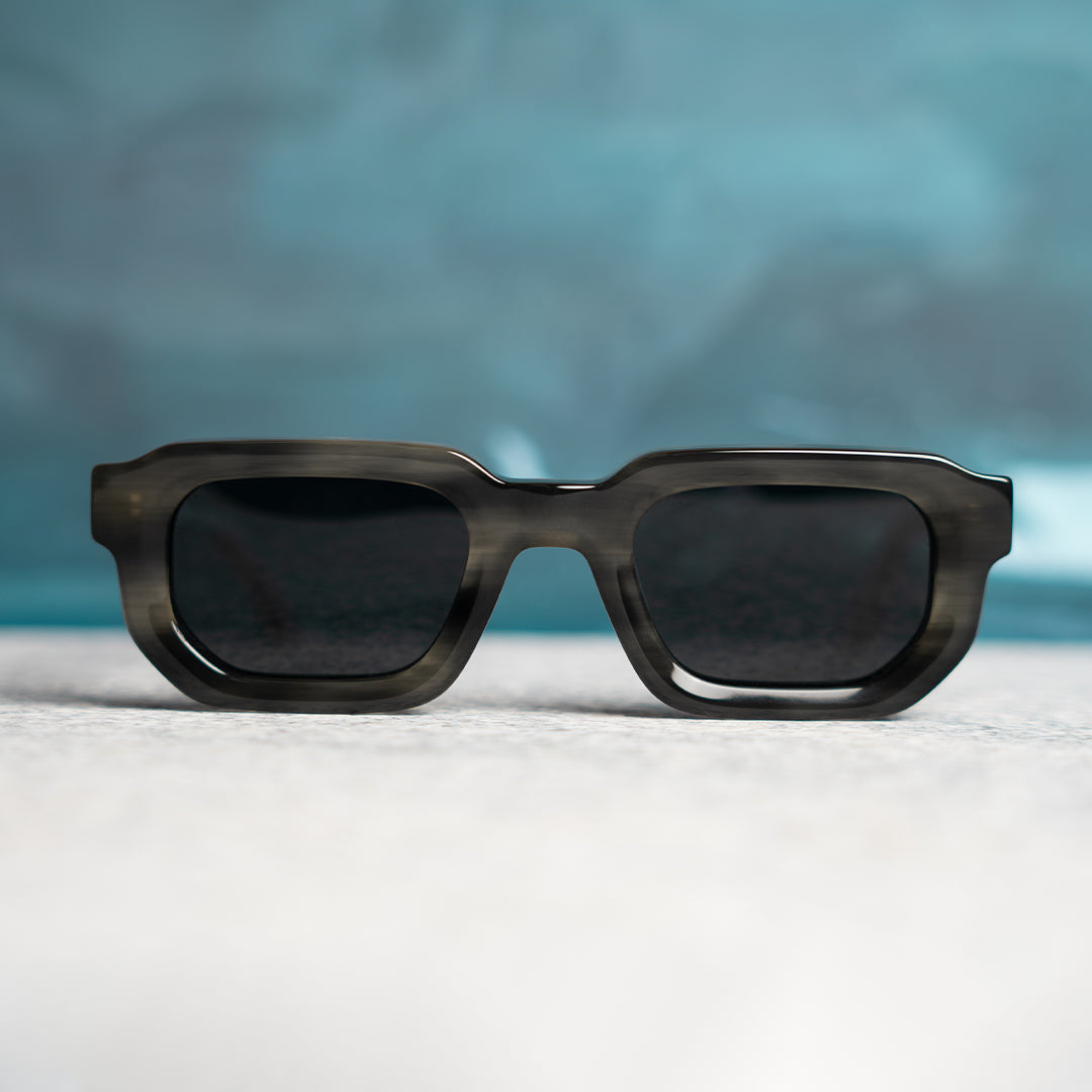 Monkstory sunglasses with a Marbleous Olive Grey frame and black lenses.