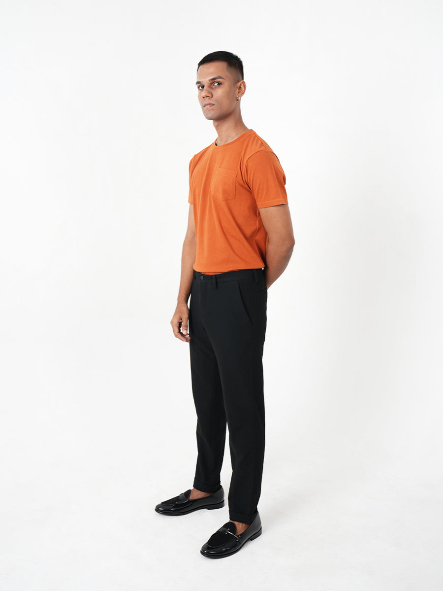 A man wearing a Monkstory bamboo cotton crew tee with a pocket, in Rusty Orange.