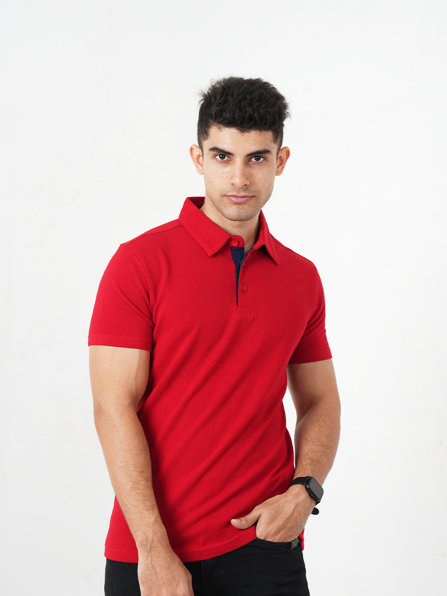 A man in a Monkstory Bamboo Cotton Polo Tee - Fiery Red adjusting his watch with comfort.