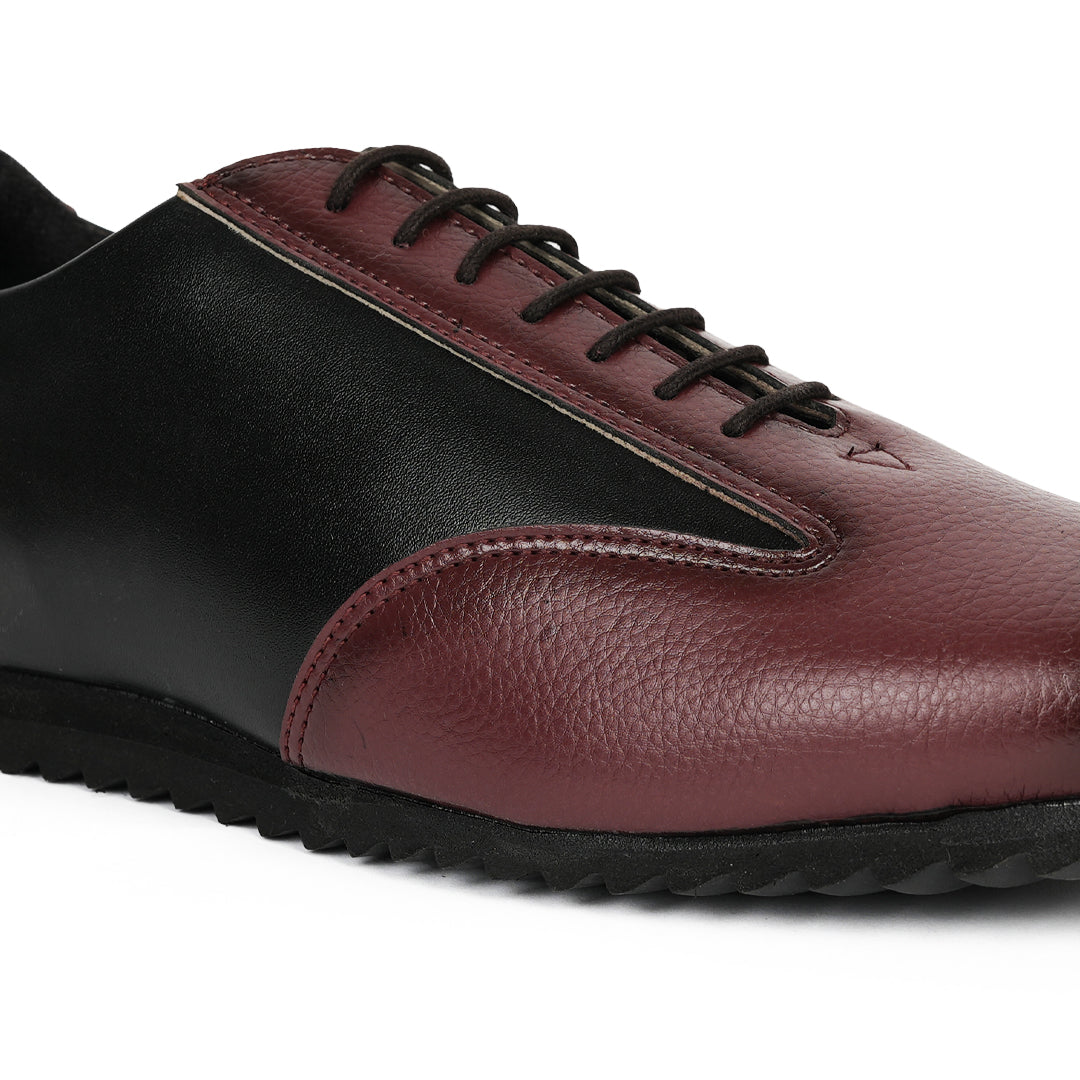 A fashionable Monkstory Dual Colour Smart Sneaker in burgundy and black leather that offers comfort.
