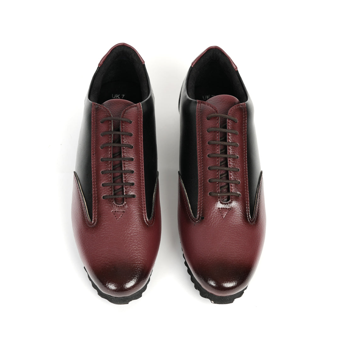 A fashionable Monkstory Dual Colour Smart Sneaker in burgundy and black leather that offers comfort.