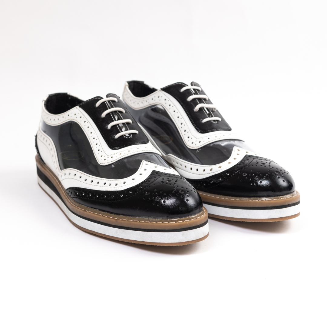 A black Trance Transparent Brogues shoe on a white background, featuring a lace-design lining for added style.
