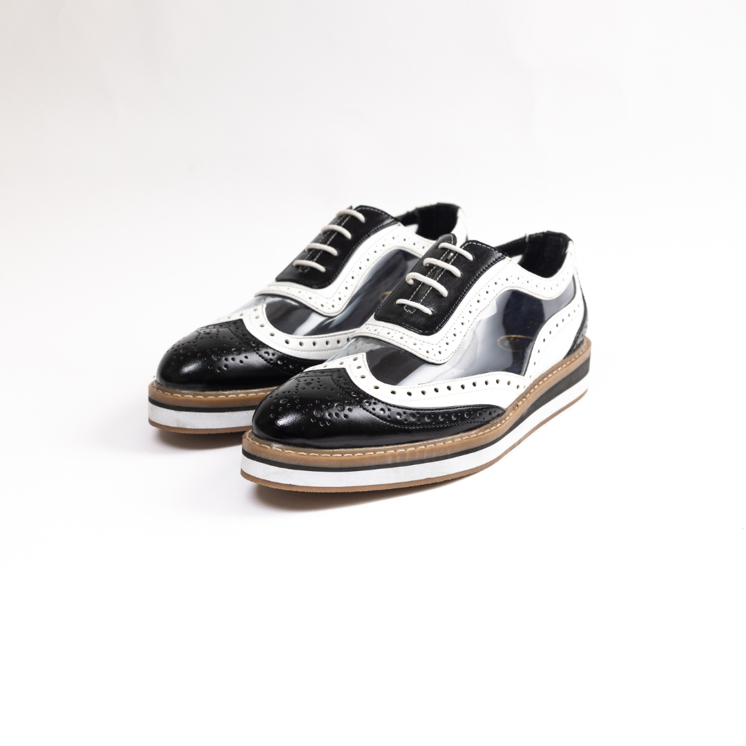 A black Trance Transparent Brogues shoe on a white background, featuring a lace-design lining for added style.