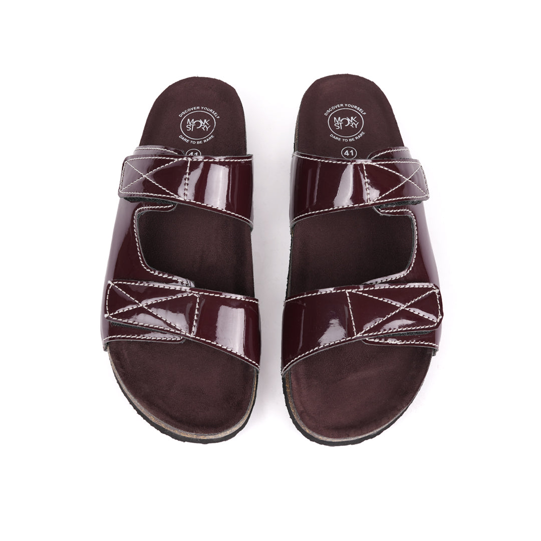 A pair of glossy brown Monkstory sandals with cork dual-straps on a white background.