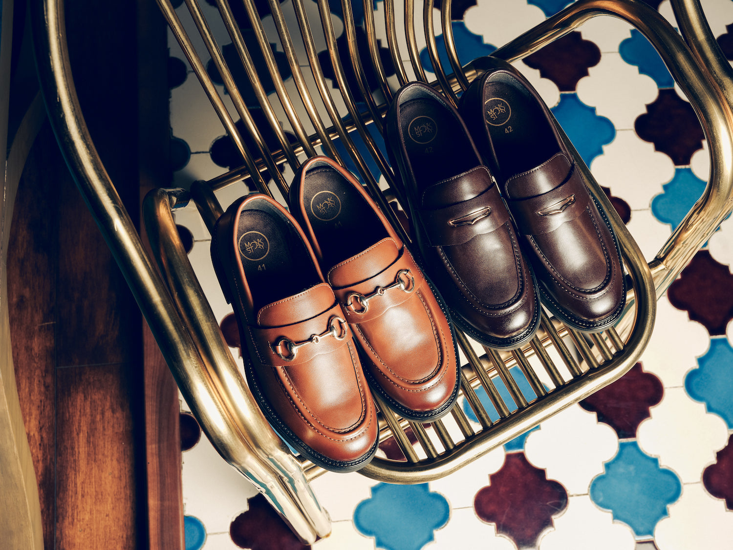 Two pairs of stylish loafers on a gray surface.