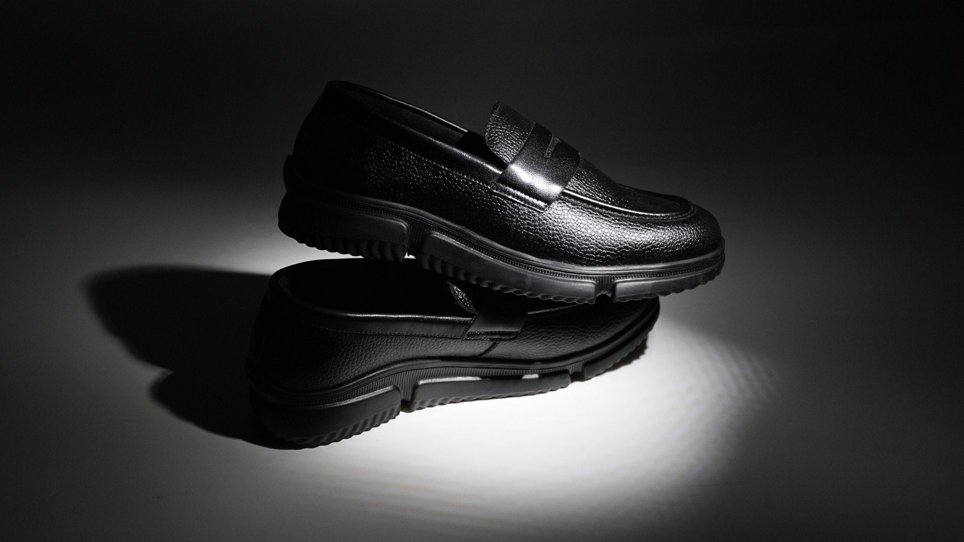 A pair of black shoes on a red background.