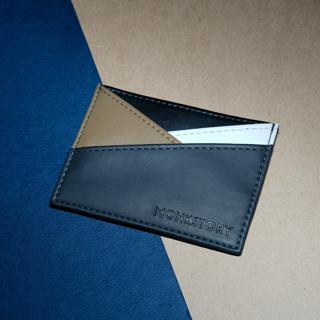 A grey Monstory Slim Colorblock Card Holder made of PU leather, showcasing monkstory brand identity, placed on a white background.