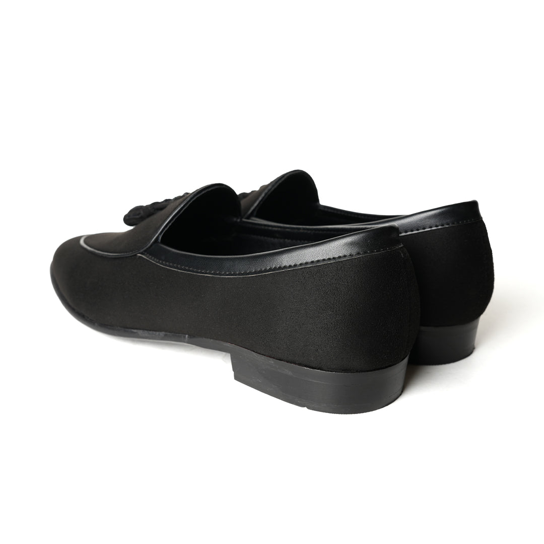 A Monkstory Tassel Slip-Ons - Black, a vegan leather loafer, with tassel on the side.