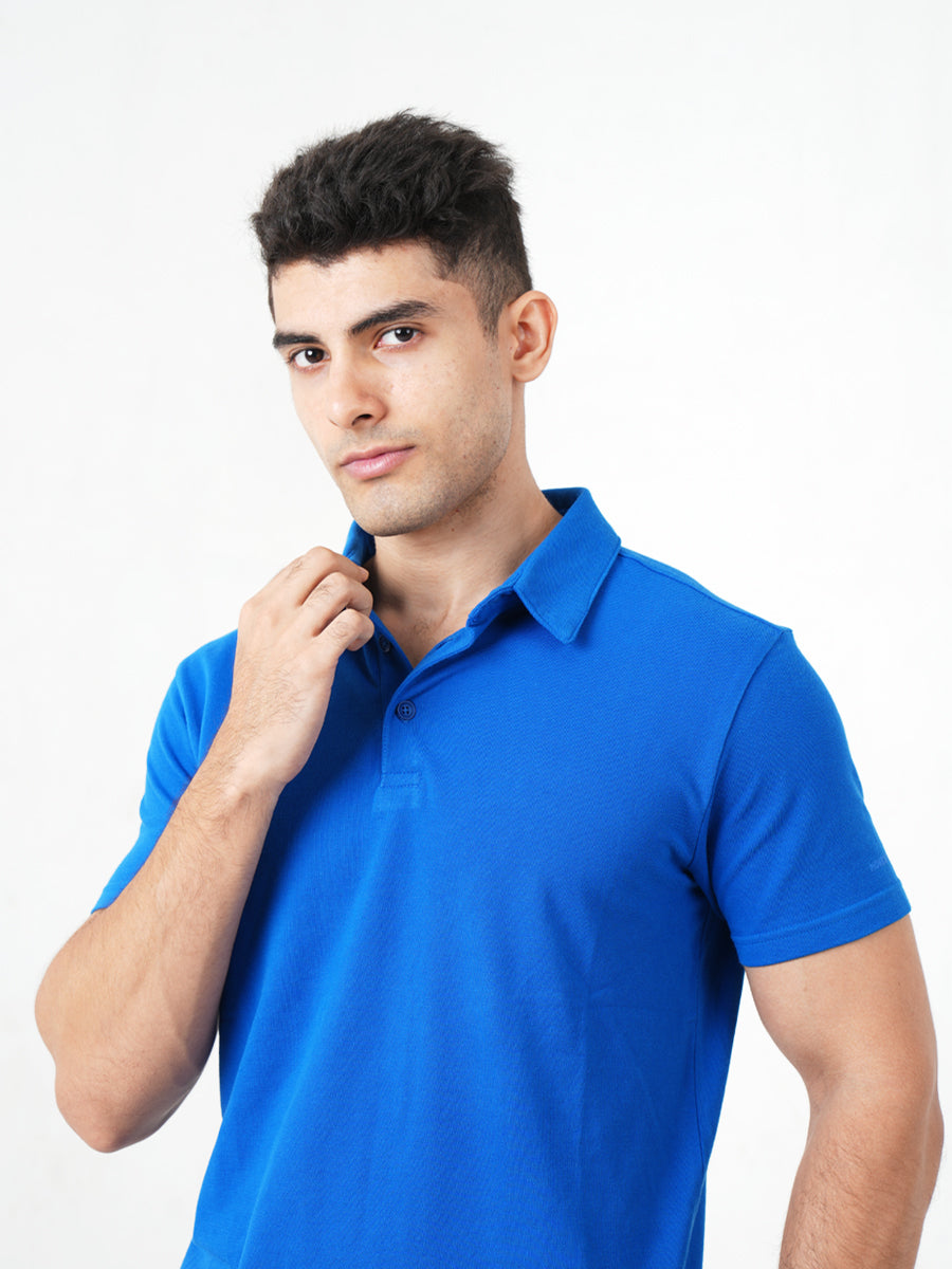 A man in a Monkstory Bamboo Cotton Polo Tee - Cobalt Blue posing for a photo, showcasing the breathable comfort and softness of the fabric.