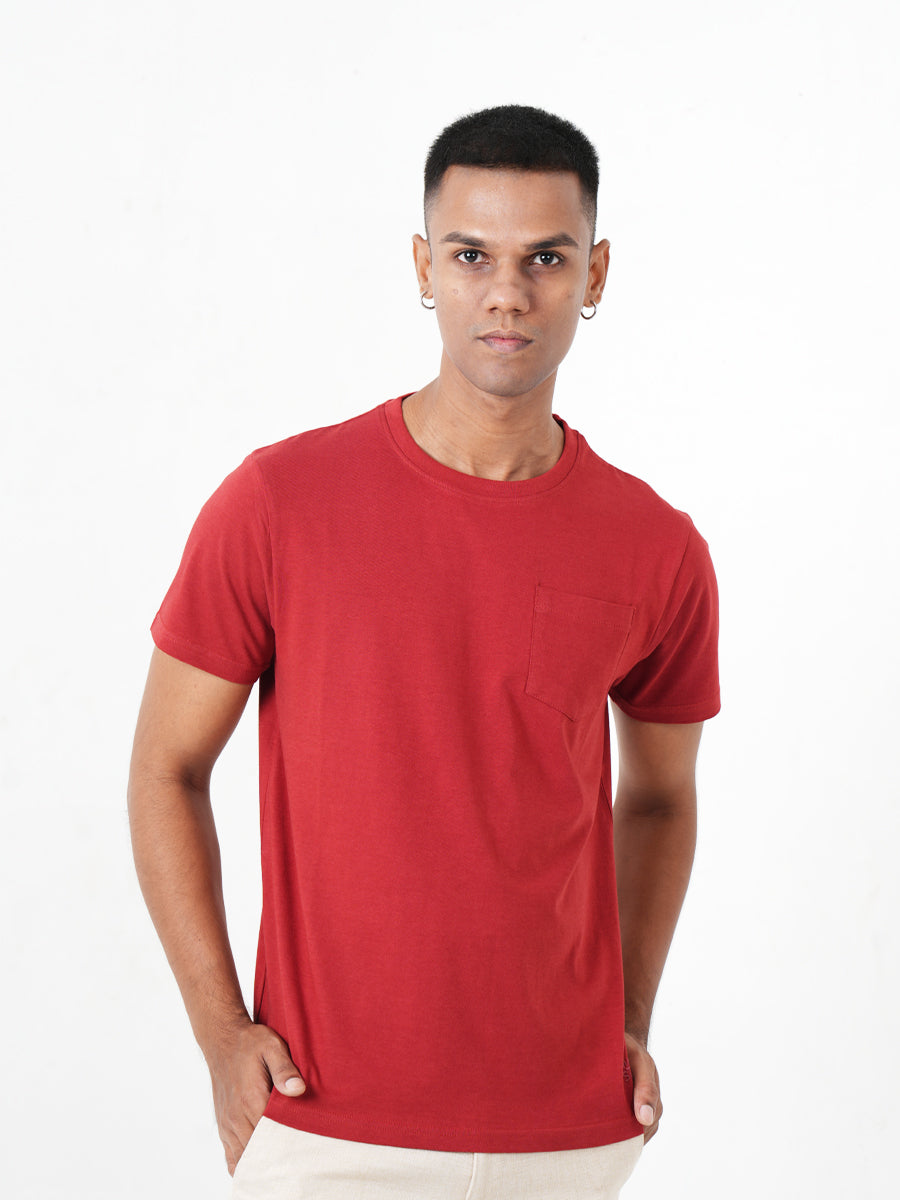 A young man in a Monkstory Bamboo Cotton Crew Tee - Terracotta Red is posing for a photo.