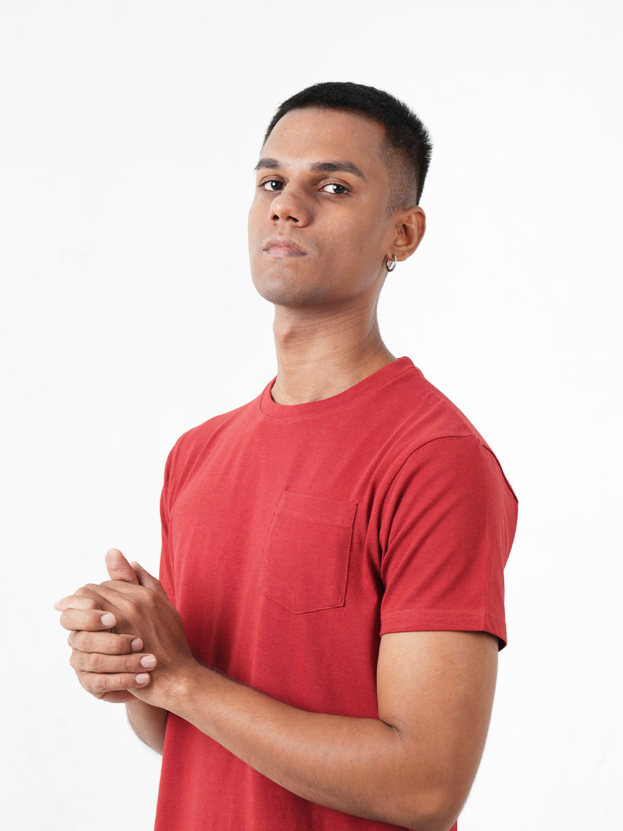 A young man in a Monkstory Bamboo Cotton Crew Tee - Terracotta Red is posing for a photo.
