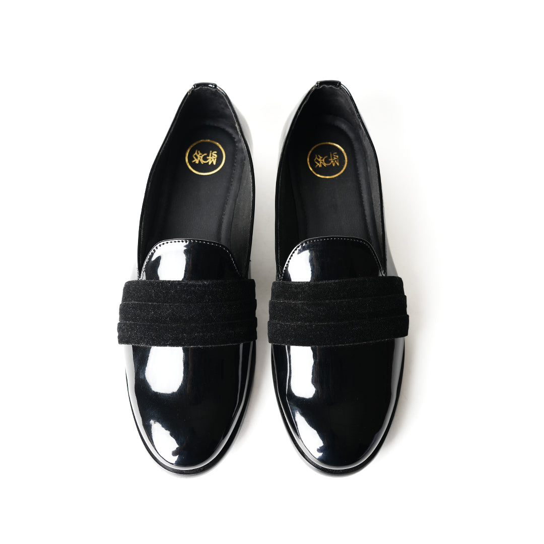 A black Tuxedo Slip-on with a patent leather finish and a bow on the side, by Monkstory.