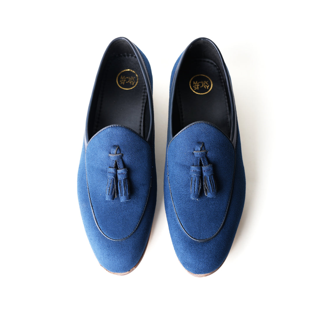 An eco-conscious blue suede Monkstory loafer with tassels, showcasing sustainability.