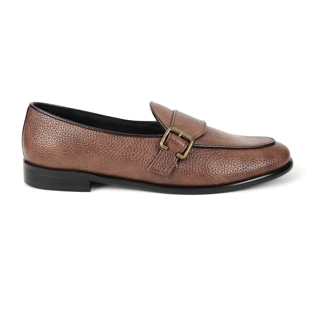 A brown leather loafer with Monkstory monkstrap buckle detailing.
