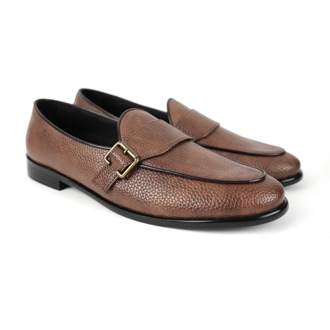 A brown leather loafer with Monkstory monkstrap buckle detailing.