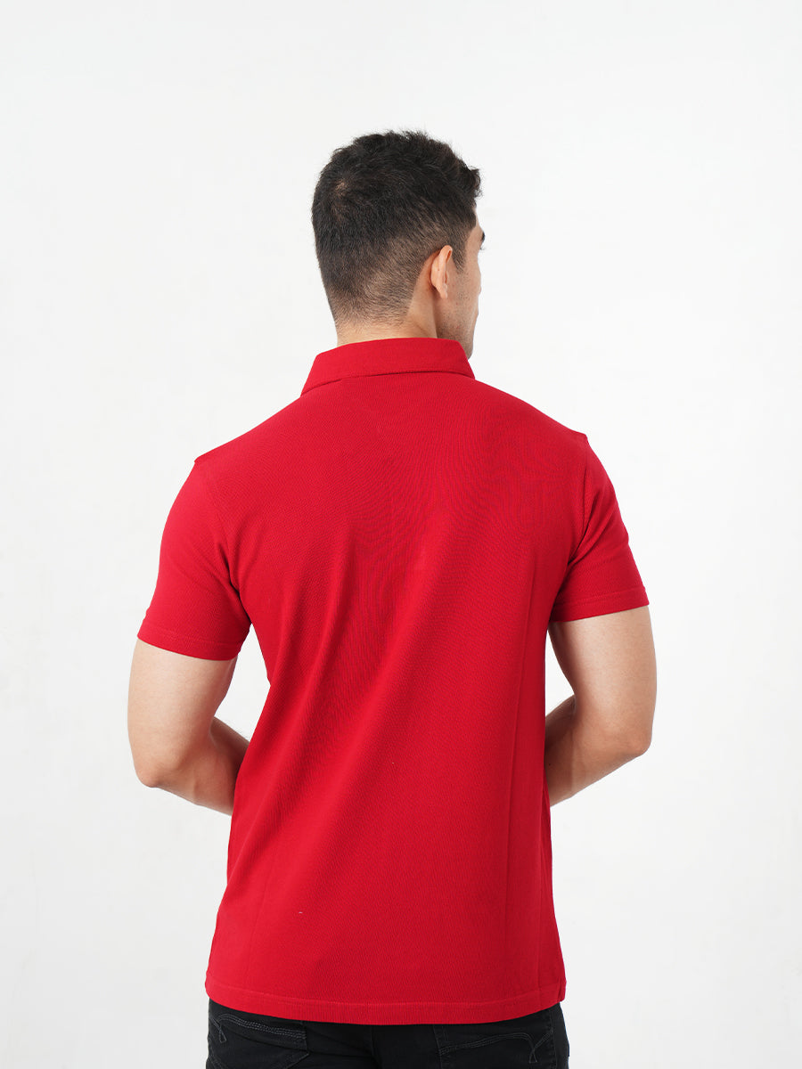 A man in a Monkstory Bamboo Cotton Polo Tee - Fiery Red adjusting his watch with comfort.