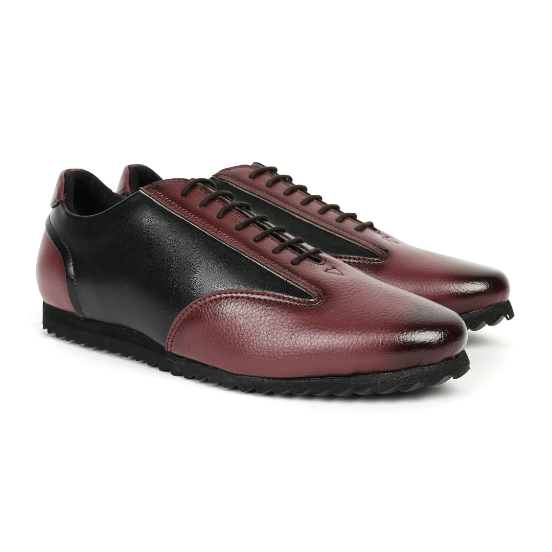 A fashionable Monkstory Dual Colour Smart Sneaker in burgundy and black leather that offers comfort.