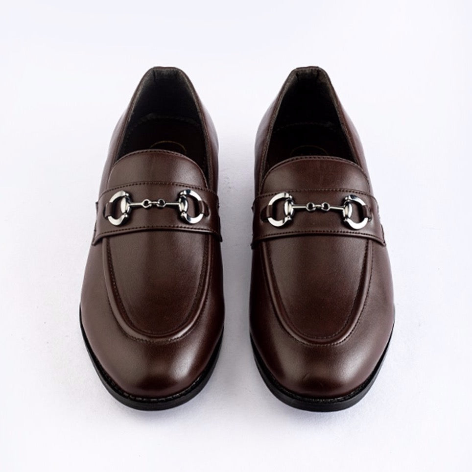 A pair of Identity Horsebit Slip-ons - Brown from monkstory, with metal buckles, perfect for those who appreciate both fashion and formal shoes.