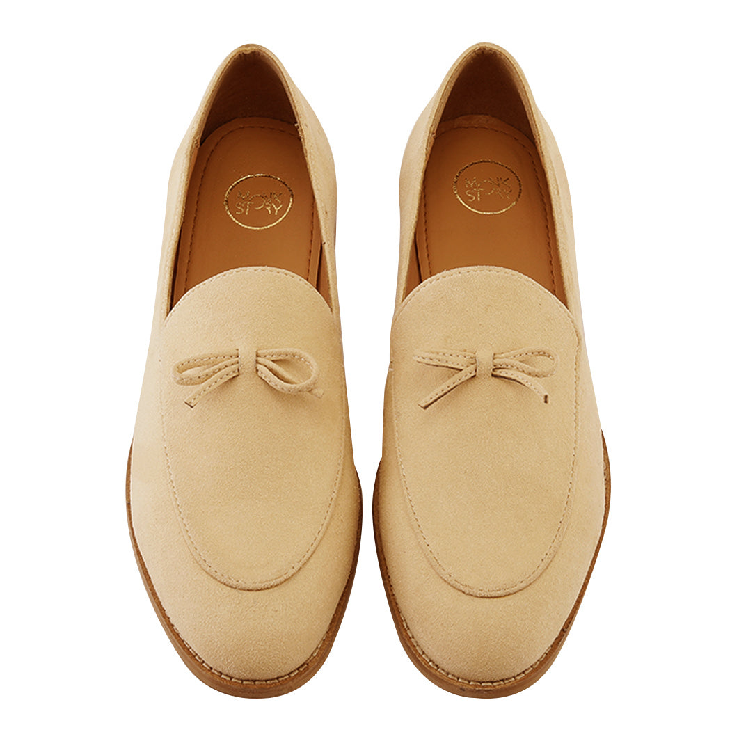 A pastel beige Wyld Faux-Suede Slip-On loafer with a tassel on the toe, perfect for fashion-forward individuals seeking pro-environment and vegan choices in their monkstory footwear.