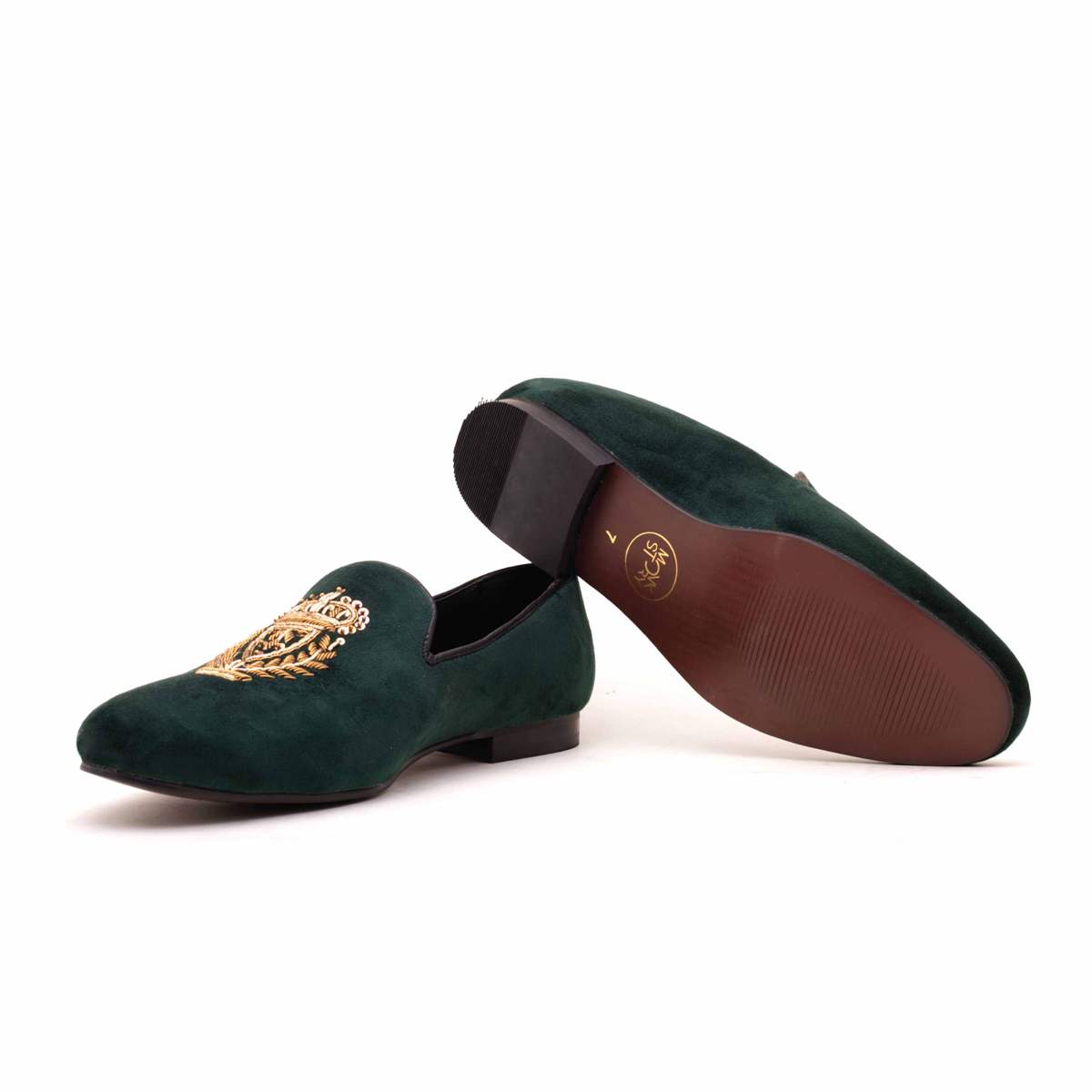 A pair of Ross Green Velvet Slip Ons with a gold crest, making them Monkstory designer shoes.