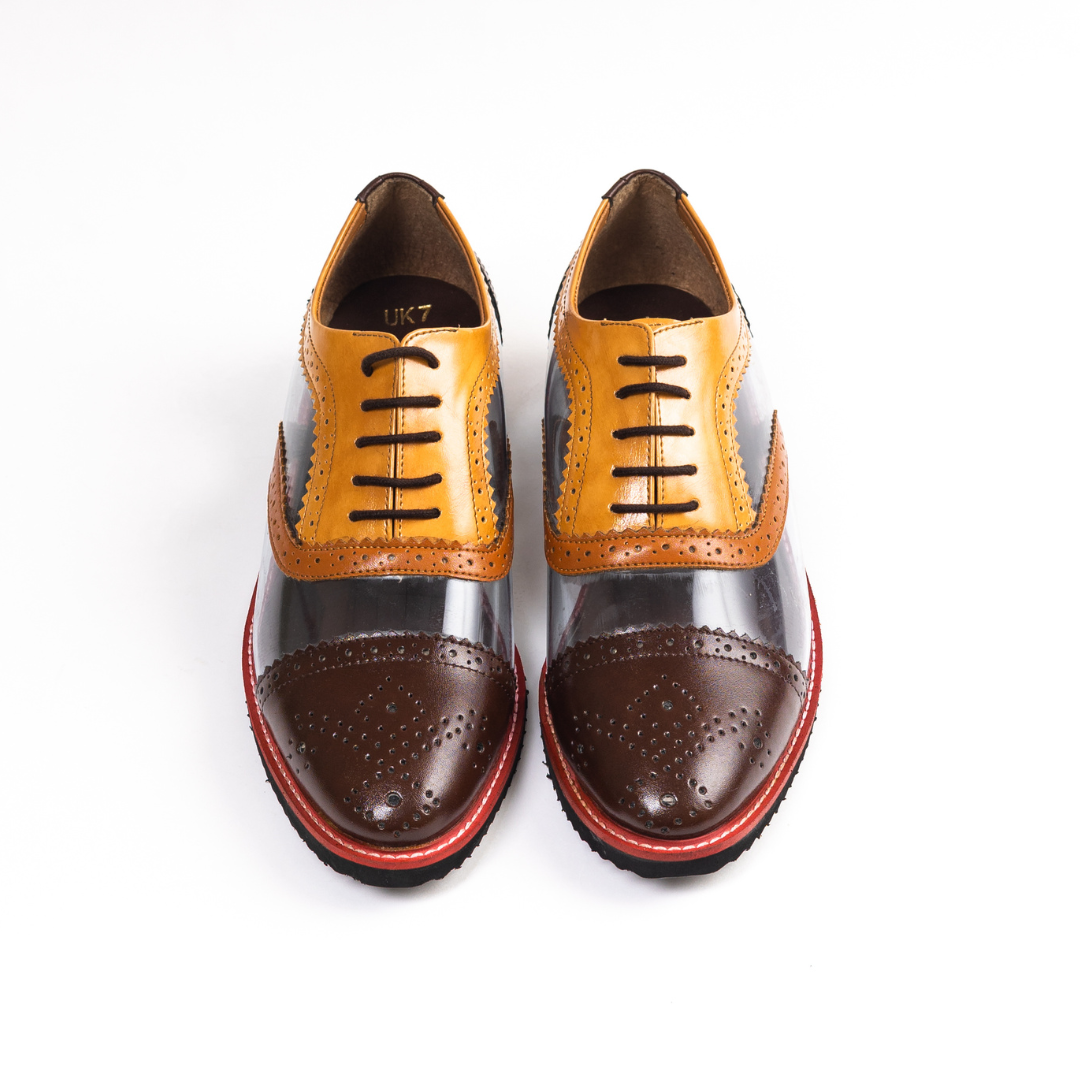 A pair of monkstory Trance Tricolour Transparent Brogues with brown-orange PU Leather soles.