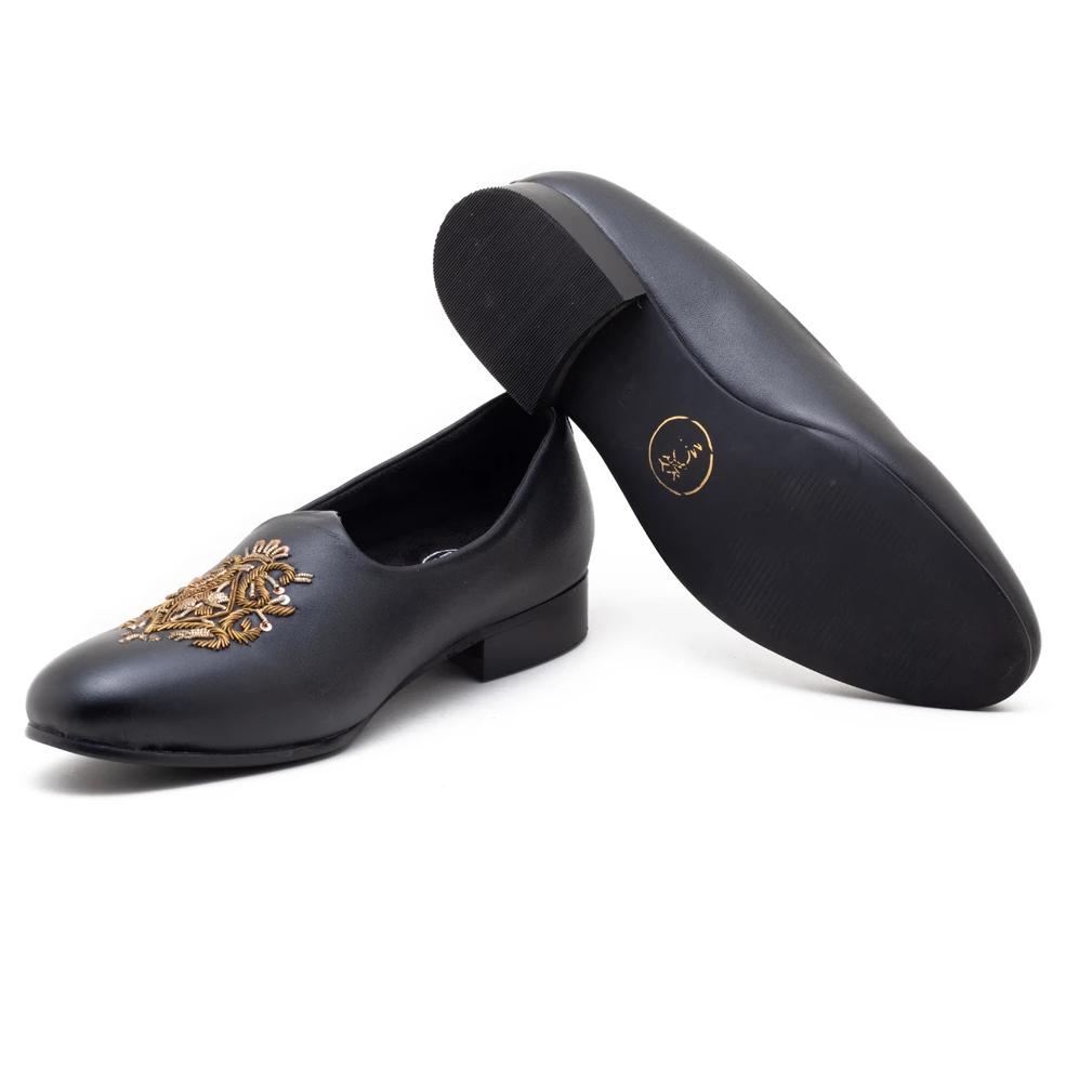 A pair of black Magenta Mojri loafers with gold adornments, perfect for those seeking a touch of luxury in their Monkstory footwear collection.