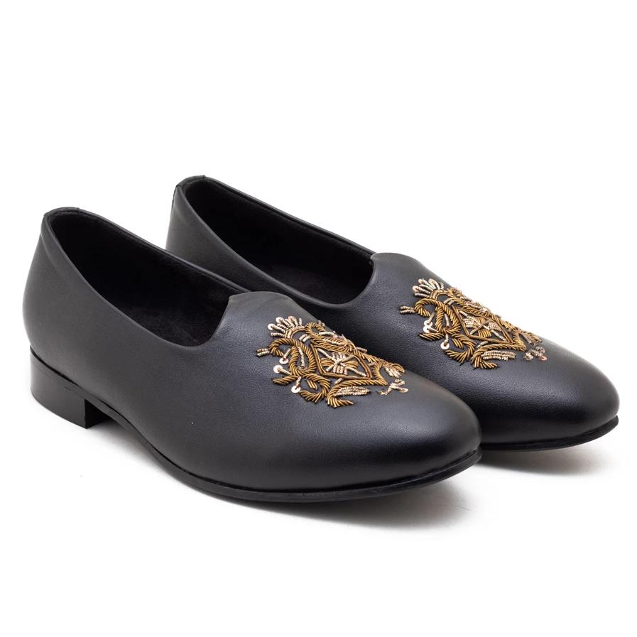 A pair of black Magenta Mojri loafers with gold adornments, perfect for those seeking a touch of luxury in their Monkstory footwear collection.