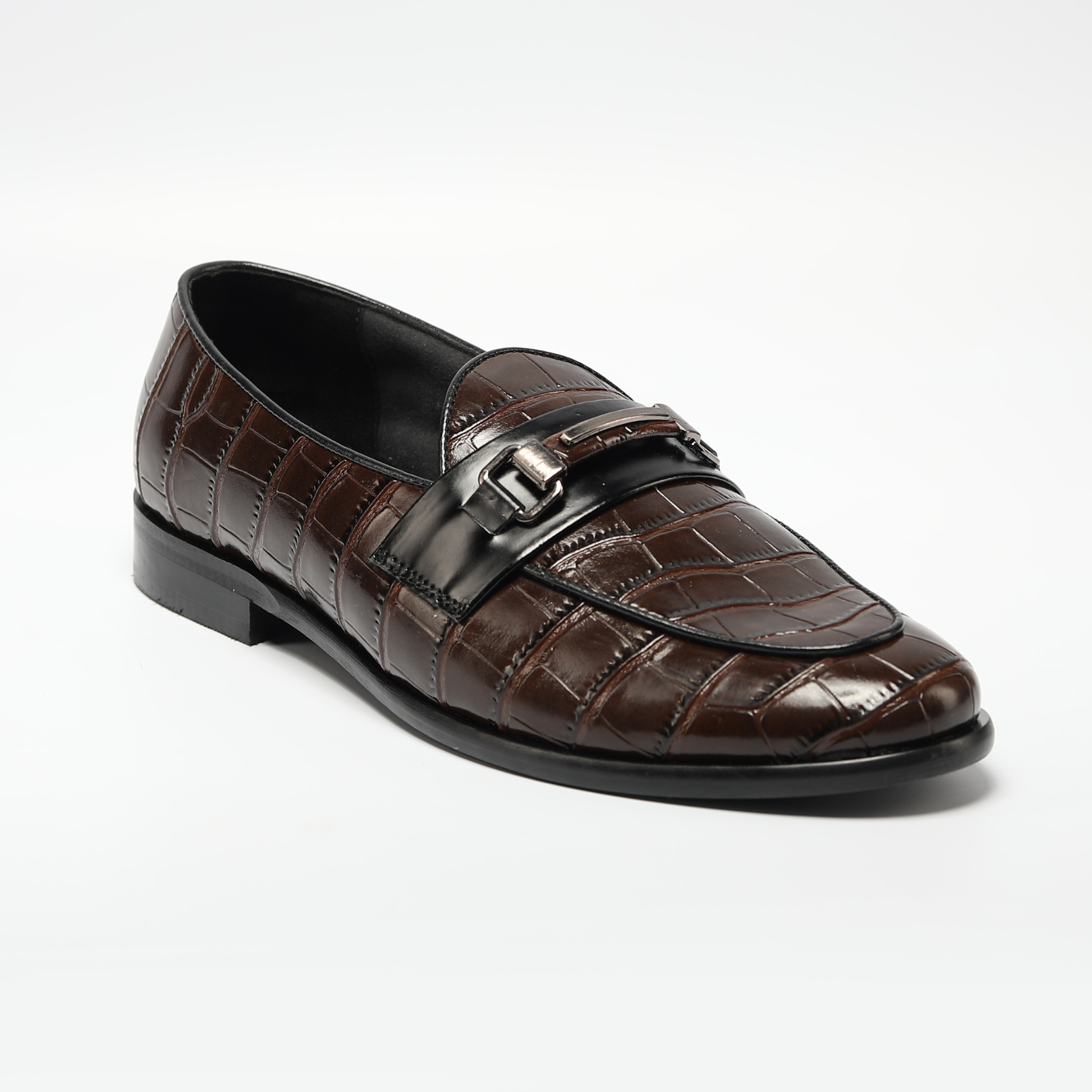 A handmade Monkstory Magnificos Classic Horsebit Slip Ons - Brown with a snake-leather look on a white background.