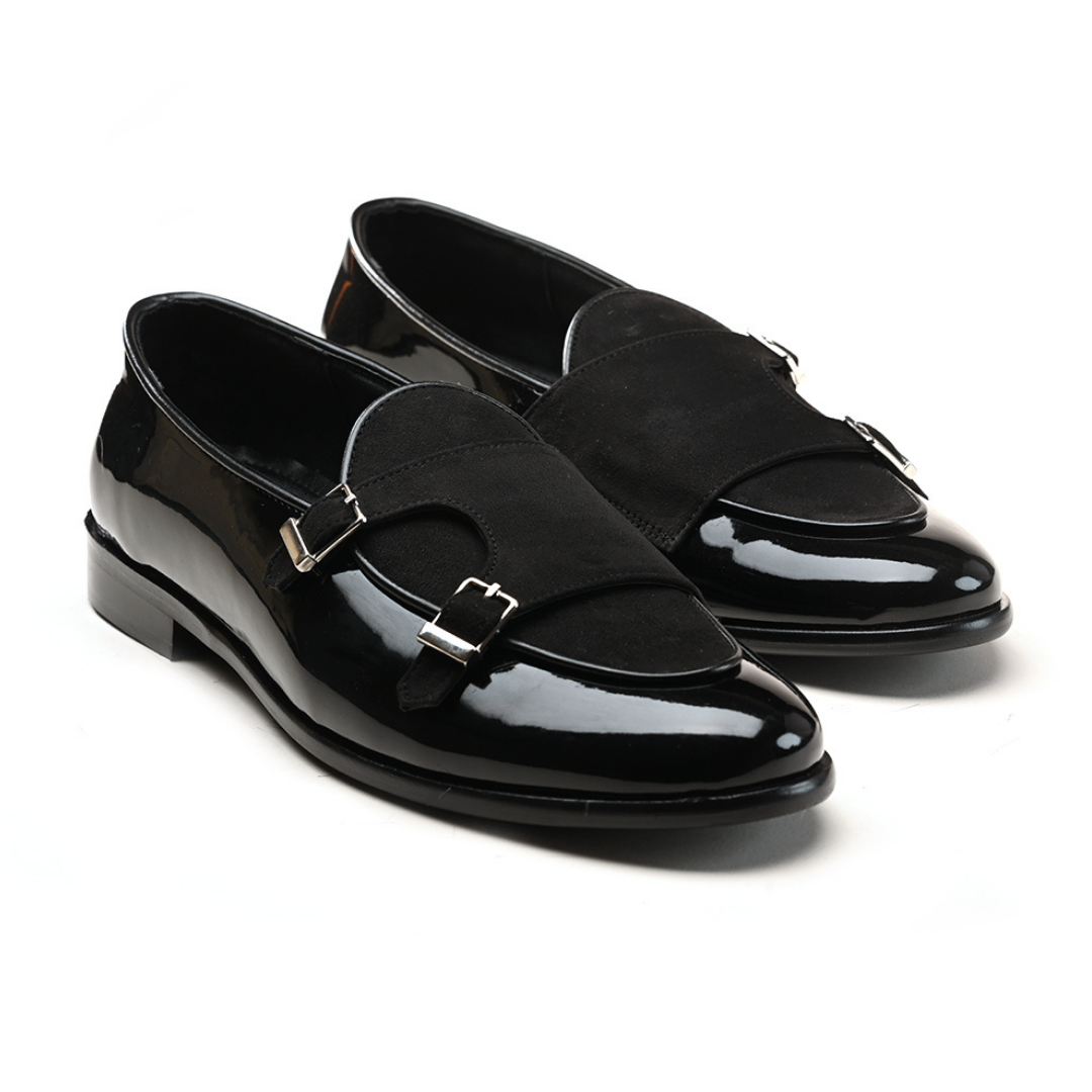 A black leather loafer with two buckles featuring posh shine.
Product: Monkstory Luxious Patent Double Monk Slip Ons - Black.
