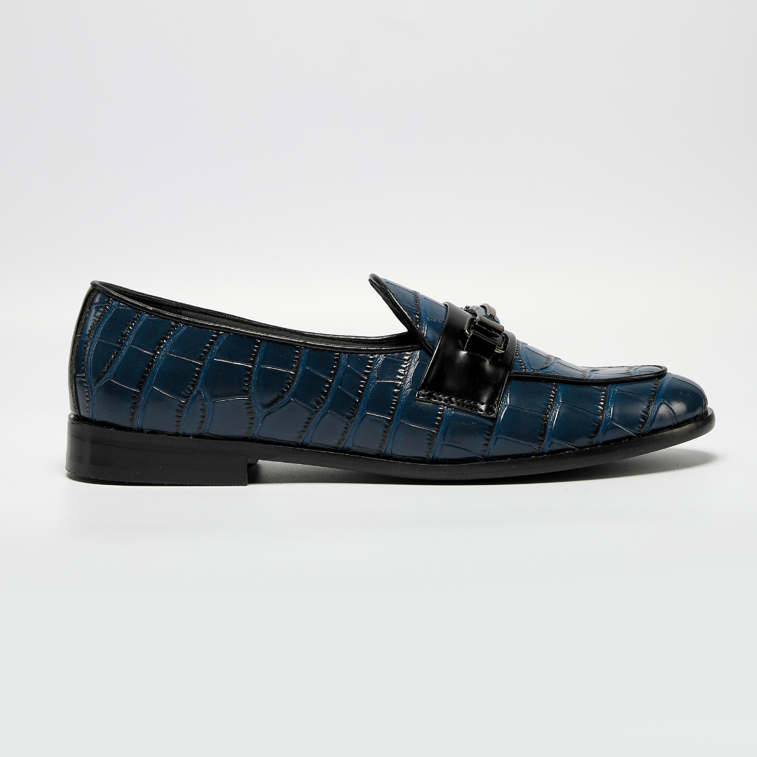 A versatile blue Magnificos Classic Horsebit Slip Ons crocodile print loafer with a black buckle, perfect for those who prefer vegan shoes. (Brand Name: Monkstory)