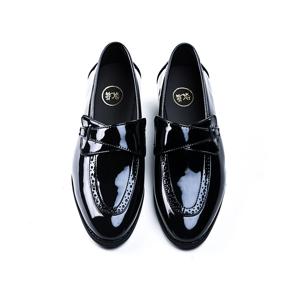 A pair of Drezzire Classic Patent Slip-Ons - Black from monkstory on a white background.