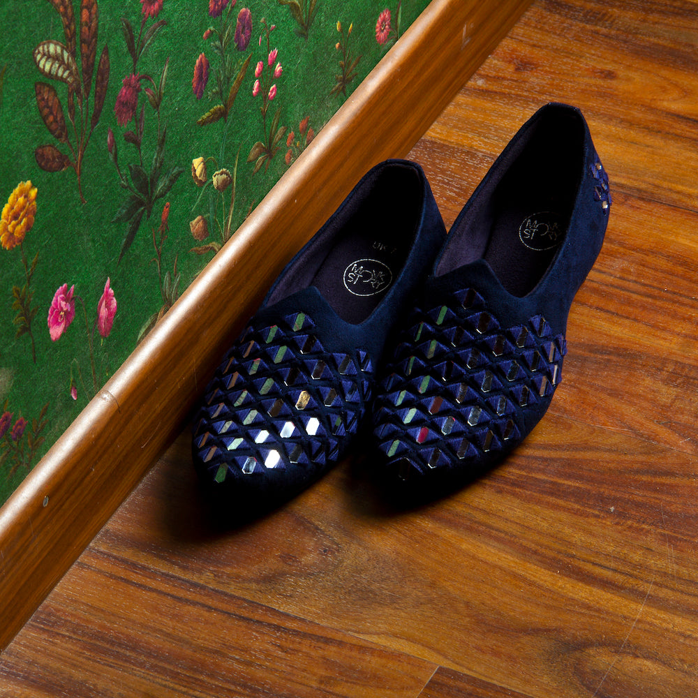 A pair of stylish Mirror Mojari - Royal Blue shoes with holes.