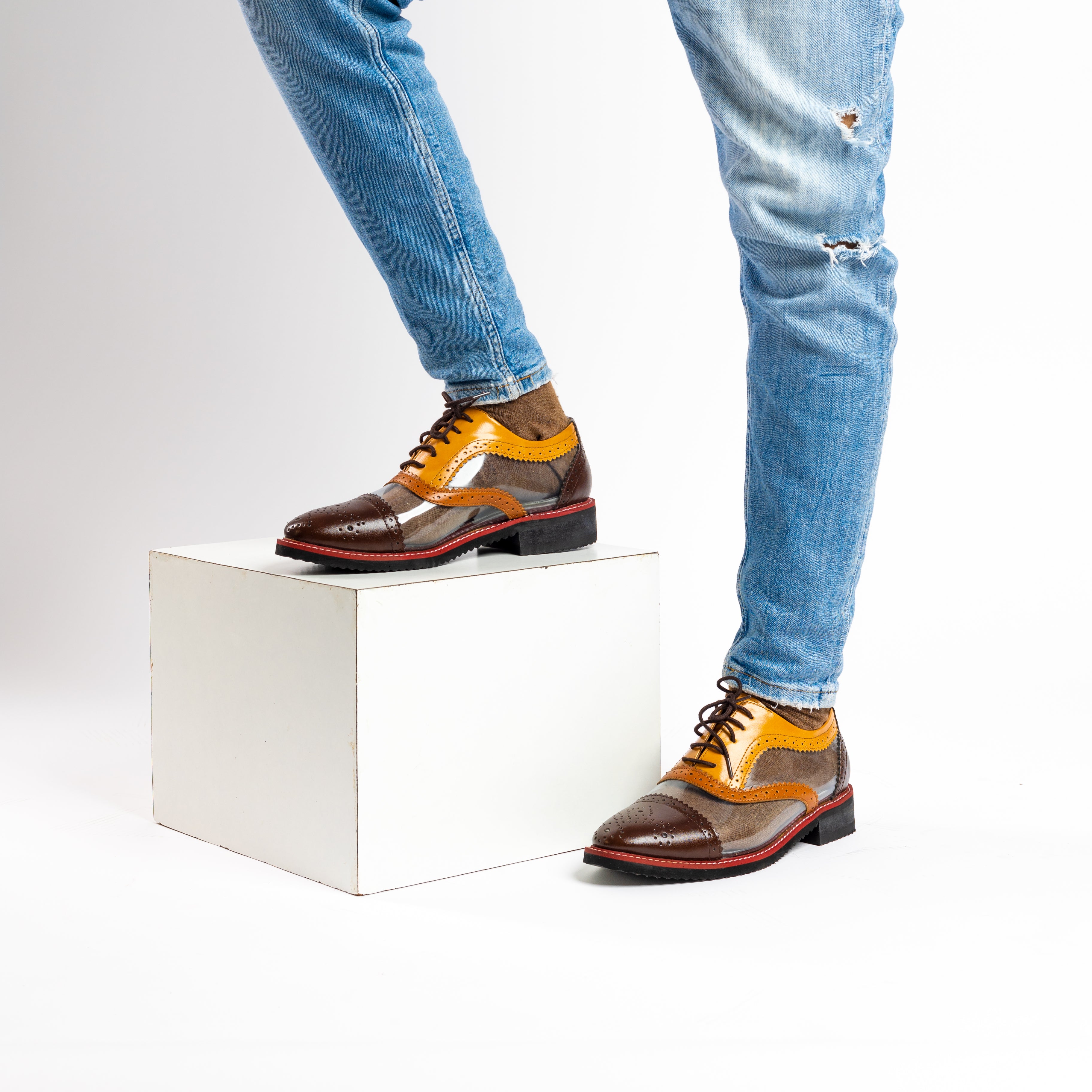 A pair of monkstory Trance Tricolour Transparent Brogues with brown-orange PU Leather soles.