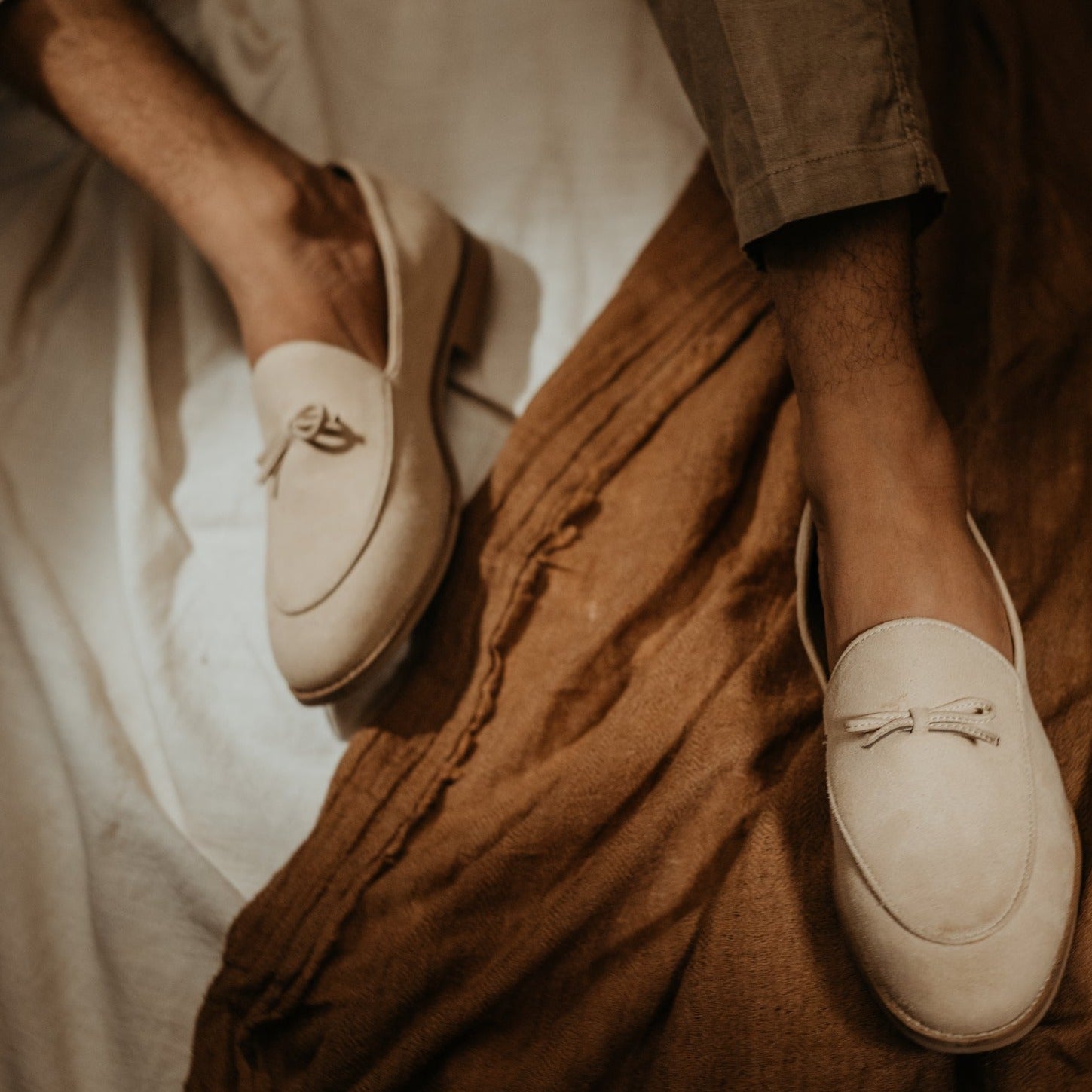 A pastel beige Wyld Faux-Suede Slip-On loafer with a tassel on the toe, perfect for fashion-forward individuals seeking pro-environment and vegan choices in their monkstory footwear.