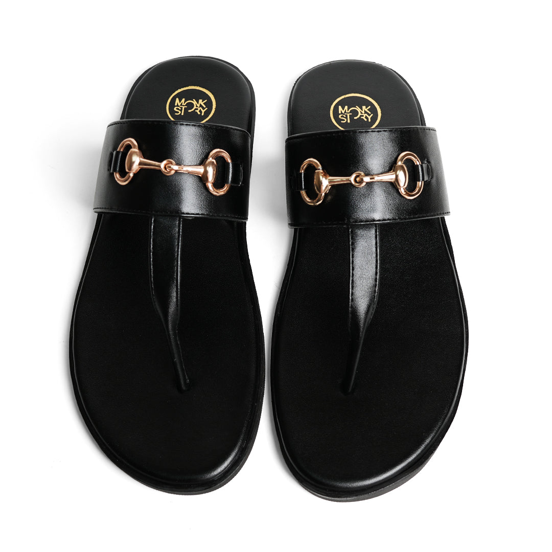 A pair of Monkstory T-Rad Horsebit Sandals in black leather with a gold buckle.